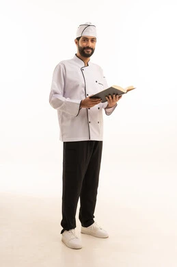 Cooking recipe review, portrait of a Saudi Arabian Gulf Arab cook wearing a cooking uniform holding a cookbook with a happy expression, full body, white background