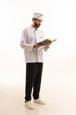 Cooking recipe review, portrait of a Saudi Arabian Gulf Arab cook wearing a cooking uniform holding a cookbook with a happy expression, full body, white background