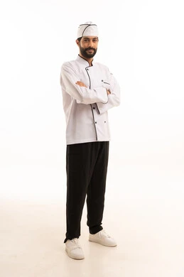 Professional Saudi cooking profession, standing straight with hands crossed in serious expression, portrait of a Saudi Arabian Gulf chef wearing cooking uniform looking at the camera with gestures of confidence and pride, full body, white background