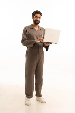 استخدام جهاز تقني حديث, المهارة و اتقان العمل، استعمال معدات الصيانة لاجراء التصليحات، بورتريه لرجل عربي سعودي خليجي يرتدي يونيفورم العمل يحمل الحاسب المحمول, الجسم بالطول الكامل، خلفية بيضاء