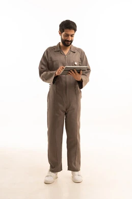 استخدام جهاز تقني حديث, المهارة و اتقان العمل، استعمال معدات الصيانة لاجراء التصليحات، بورتريه لرجل عربي سعودي خليجي يرتدي يونيفورم العمل يحمل جهاز التابلت اللوحي, الجسم بالطول الكامل، خلفية بيضاء