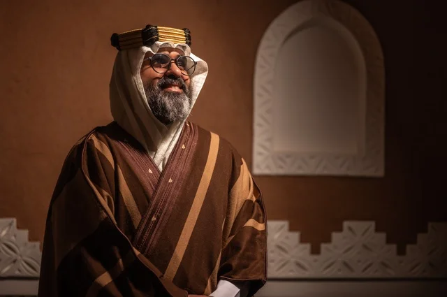 الحنين والأصالة  للأيام القديمة، رجل عربي سعودي مسن ينظر إلى الكاميرا بإيماءات الوقار والسرور يرتدي الزي العربي التقليدي يقف داخل غرفة تراثية بديكورات جدران مزخرفة، يرتدي عباءة واسعة وعقالًا على رأسه، ويبدو بلحية بيضاء، الحكمة والتجربة الطويلة في الحياة،