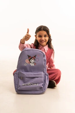 Preparing for the new school year, expressions and gestures of happiness and pleasure, portrait of a smiling Saudi Arabian Gulf girl wearing a school uniform packing her school bag, getting ready to go to the first day of school, love of learning and education, white background