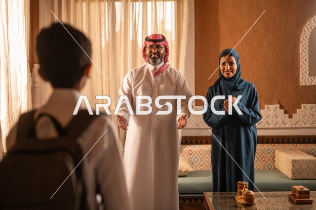 وقت العودة من المدرسة، إظهار مشاعر المودة والمحبة العائلية, عائلة عربية خليجية سعودية تقف داخل غرفة تراثية بديكورات جدران مزخرفة,  في الخلفية تفاصيل المكان المزخرف مع لمسات ديكور تراثية عربية