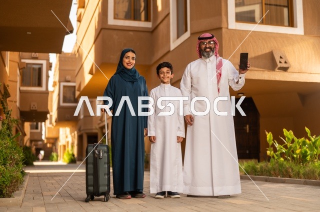A black background displayed on a mobile phone, spending an entertaining summer trip, the atmosphere of the Gulf family and family bonding, a Saudi Arabian Gulf Arab family standing at the entrance of a modern home, the father wearing a white thobe with a ghutrah and agal, the child wearing a traditional white thobe, the mother holding a suitcase in her hand.