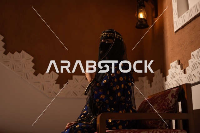 الفخر بالهوية الوطنية, إظهار مشاعر حب الوطن والانتماء إليه, إمرأة عربية خليجية سعودية ترتدي العباءة السوداء والبرقع تجلس في بيت تراثي قديم, يوم بدينا 1727 م, ذكرى تأسيس الدولة السعودية الأولى في 22 فبراير، ارتداء الأزياء الشعبية التقليدي
