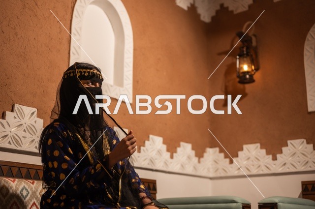 الفخر بالهوية الوطنية, إظهار مشاعر حب الوطن والانتماء إليه, إمرأة عربية خليجية سعودية ترتدي العباءة السوداء والبرقع تجلس في بيت تراثي قديم, يوم بدينا 1727 م, ذكرى تأسيس الدولة السعودية الأولى في 22 فبراير، ارتداء الأزياء الشعبية التقليدي