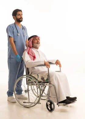 مفهوم الرعاية الصحية والاعتناء بالمرضى والمقعدين، نمط حياة ذوي الهمم، ايماءات السرور والسعادة، بورتريه لممرض يرتدي اليونيفورم والكمامة يقوم بالاعتناء برجل عربي خليجي سعودي مقعد يرتدي الثوب التقليدي والشماغ يجلس على كرسي متحرك، صورة لكامل الجسم، خلفية بيضاء