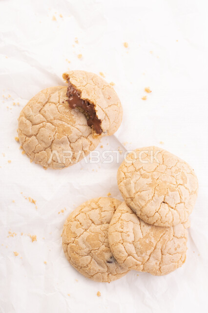 صورة لقطع من البسكويت المقرمش متناثر على الطاولة , قطع البسكويت المحشوة بقطع الشوكولاتة  . 