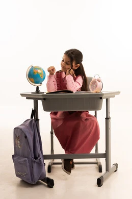 أهمية التعليم في بناء مستقبل مشرق للمجتمع ، مفهوم البحث والإستكشاف حول العالم، بورتريه لطالبة عربية خليجية سعودية ترتدي الزي المدرسي تجلس على طاوله مكتبية تقوم بمذاكره الدروس المدرسيه، خلفية بيضاء