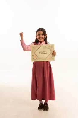 النجاح وانتهاء العام الدراسي، مفهوم التفوق والتخرج من المدرسة, النظر الى الكاميرا بايماءات الفخر والسعاده, جودة التعليم في السعوديه, بورتريه  لطالبة عربية سعودية خليجية مبتسمة ترتدي الزي المدرسي تمسك بيدها الشهادة، الجسم بالطول الكامل، خلفية بيضاء