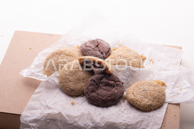 صورة لقطع من البسكويت المقرمش متناثر على الطاولة , قطع البسكويت المحشوة بقطع الشوكولاتة  . 