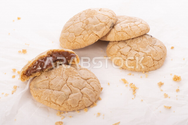 صورة لقطع من البسكويت المقرمش متناثر على الطاولة , قطع البسكويت المحشوة بقطع الشوكولاتة  . 