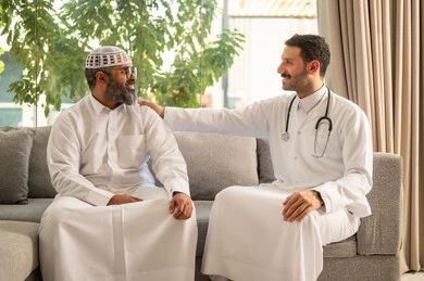 تقديم أفضل الخدمات الصحية لمرضى كبار السن في المستشفى، ممرض يرتدي اليونيفورم الخاص يقوم بطمأنة رجل عربي خليجي سعودي يرتدي الزي التقليدي ، مفهوم الطب والرعاية الصحية، تقدير الطبيب لجهوده ورعايته الطبية