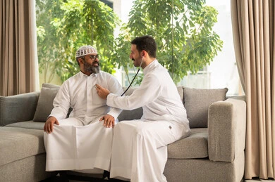 قياس  معدل ضربات القلب, مفهوم الطب والرعاية الصحية, المتابعة الدورية لفحص نبضات القلب, طبيب عربي خليجي سعودي يرتدي المعطف الطبي يقوم باستخدام سماعه الفحص الطبية لمريض كبير بالسن