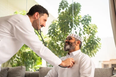 قياس  معدل ضربات القلب, مفهوم الطب والرعاية الصحية, المتابعة الدورية لفحص نبضات القلب, طبيب عربي خليجي سعودي يرتدي المعطف الطبي يقوم باستخدام سماعه الفحص الطبية لمريض كبير بالسن