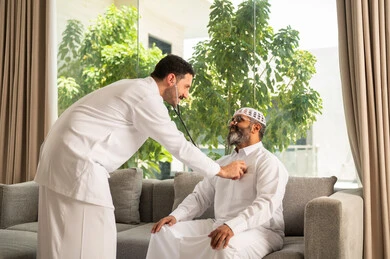 قياس  معدل ضربات القلب, مفهوم الطب والرعاية الصحية, المتابعة الدورية لفحص نبضات القلب, طبيب عربي خليجي سعودي يرتدي المعطف الطبي يقوم باستخدام سماعه الفحص الطبية لمريض كبير بالسن