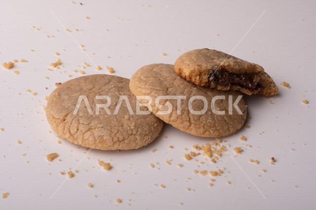 صورة لقطع من البسكويت المقرمش متناثر على الطاولة , قطع البسكويت المحشوة بقطع الشوكولاتة  . 