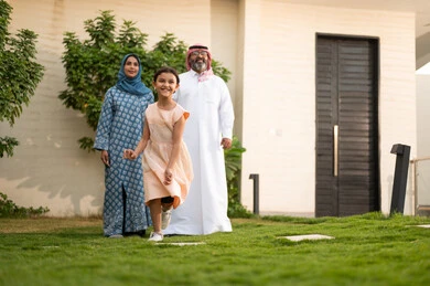  المحافظة على الترابط الأسري، الاعتناء والاهتمام بالاولاد, اللعب والتسلية والترفيه مع العائلة في الهواء الطلق, قضاء أوقات ممتعه مع الأهل الأبناء، زوجان عربيان خليجيان سعوديان يلعبان في الحديقة مع ابنتهما بإيماءات السعادة