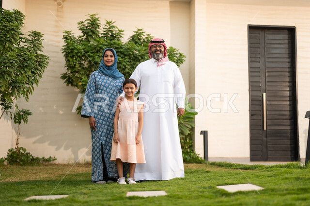  المحافظة على الترابط الأسري، الاعتناء والاهتمام بالاولاد, اللعب والتسلية والترفيه مع العائلة في الهواء الطلق, قضاء أوقات ممتعه مع الأهل الأبناء، زوجان عربيان خليجيان سعوديان يلعبان في الحديقة مع ابنتهما بإيماءات السعادة