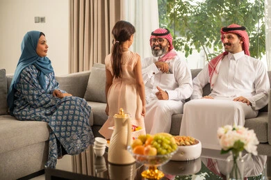 تقديم العيدية في العيد، مفهوم الحب والحنان، دور الأب في حياه الأبناء، جد عربي خليجي سعودي يرتدي الثوب التقليدي والشماغ يجلس على كرسي يعطي الفلوس لحفيدته، عادات وتقاليد الاعياد والمناسبات الدينية، ايماءات السعادة والسرور،  اجواء اسرية مليئة بالفرح