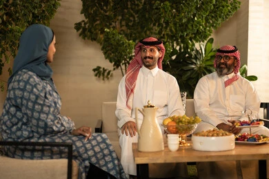 Kinship ties and family bonds, children's joy and happiness during the happy Eid days, family gatherings and visits during Islamic holidays and occasions, a Saudi Arabian Gulf family sitting outside with gestures of joy and happiness, Eid hospitality and sweets, good reception and hospitality of the guest