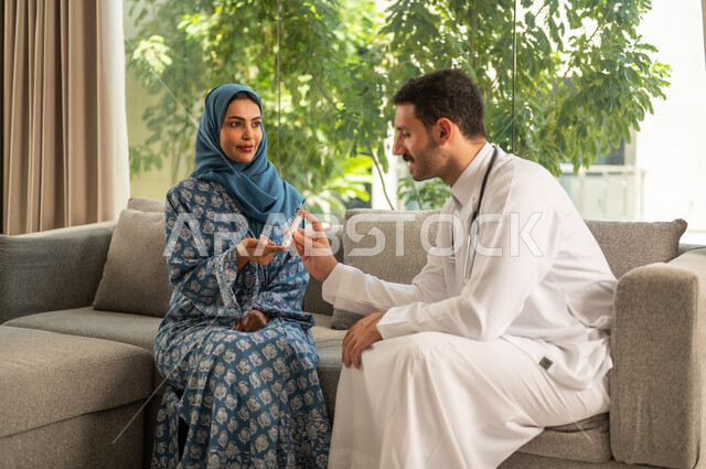المتابعة الدورية لمرضى داء السكري, الفحوصات الطبية السريعة لمعرفة نسبة السكر في الدم، استخدام الأجهزة الالكترونية للتحاليل المنزلية، شابة سعودية مصابة بحالة مرضية مزمنة, طبيب عربي خليجي سعودي يرتدي المعطف الطبي يقوم بوخز اصبع امرأة