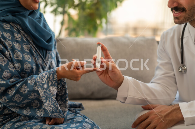 الفحوصات الطبية السريعة لمعرفة نسبة السكر في الدم، استخدام الأجهزة الالكترونية للتحاليل المنزلية، شابة سعودية مصابة بحالة مرضية مزمنة, طبيب عربي خليجي سعودي يرتدي المعطف الطبي يقوم بوخز اصبع امرأة, المتابعة الدورية لمرضى داء السكري