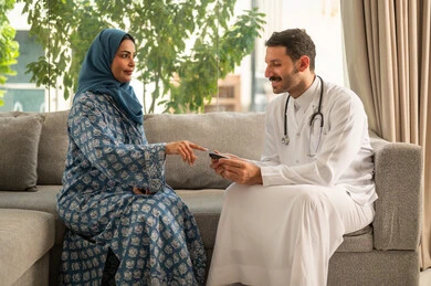 الفحوصات الطبية السريعة لمعرفة نسبة السكر في الدم، استخدام الأجهزة الالكترونية للتحاليل المنزلية، شابة سعودية مصابة بحالة مرضية مزمنة, طبيب عربي خليجي سعودي يرتدي المعطف الطبي يقوم بوخز اصبع امرأة, المتابعة الدورية لمرضى داء السكري