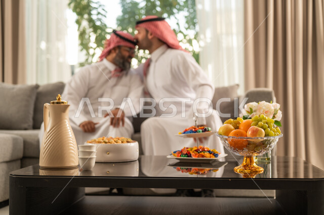 الحصول على الرضى، مفهوم الحب والحنان، دور الأب في حياه الأبناء، رجل عربي خليجي سعودي يرتدي الثوب التقليدي والشماغ يقوم بتقبيل رأس والده، قضاء وقت ممتع ومسلي، ايماءات السعادة والسرور،  اجواء اسرية مليئة بالفرح