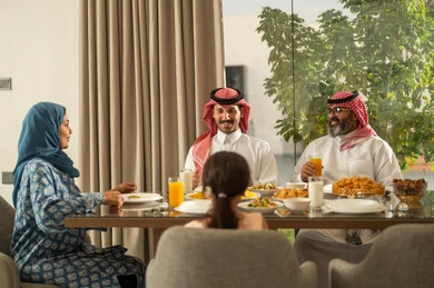  اجتماع الأسرة حول مائدة الإفطار المليئة بأصناف المأكولات والمقبلات الشهية، موعد كسر الصيام عند أذان المغرب في رمضان المبارك، فطور رمضاني عائلي، عائلة عربية خليجية سعودية تجلس بايماءات السرور, حسن الضيافة وإكرام الأخرين, أجواء عائلية روحانية دينية إسلامية