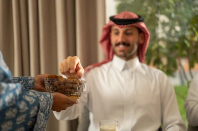كسر الصيام بالتمر عند أذان المغرب في رمضان المبارك، فطور رمضاني عائلي، عائلة عربية خليجية سعودية تجلس بايماءات السرور, حسن الضيافة وإكرام الأخرين, أجواء عائلية روحانية دينية إسلامية, اجتماع الأسرة حول مائدة الإفطار المليئة بأصناف المأكولات والمقبلات الشهية كسر الصيام بالتمر عند أذان المغرب في رمضان المبارك، فطور رمضاني عائلي، عائلة عربية خليجية سعودية تجلس بايماءات السرور, حسن الضيافة وإكرام الأخرين, أجواء عائلية روحانية دينية إسلامية, اجتماع الأسرة حول مائدة الإفطار المليئة بأصناف المأكولات والمقبلات الشهية