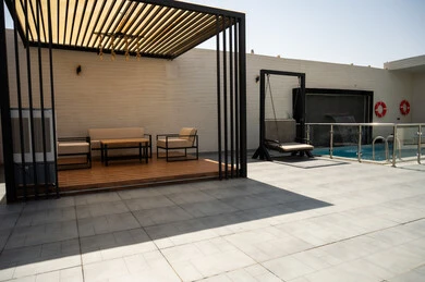  جلسة خارجية هادئة امام حوض السباحة، أثاث منزلي فاخر في احدى الشاليهات، التصميم الداخلي للجلسات على الطراز الحديث, تجهيز السويت بكافة المفروشات الراقية, ديكور داخلي راقي للفلل والشقق السكنية في المملكة العربية السعودية