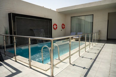 A quiet outdoor seating area in front of the swimming pool, luxurious home furnishings in a chalet, modern interior design for seating areas, suites furnished with all the finest furnishings, elegant interior design for villas and residential apartments in the Kingdom of Saudi Arabia.