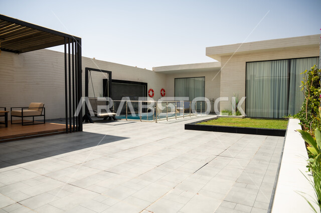 A quiet outdoor seating area in front of the swimming pool, luxurious home furnishings in a chalet, modern interior design for seating areas, suites furnished with all the finest furnishings, elegant interior design for villas and residential apartments in the Kingdom of Saudi Arabia.