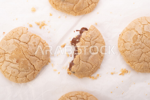 صورة لقطع من البسكويت المقرمش متناثر على الطاولة , قطع البسكويت المحشوة بقطع الشوكولاتة  . 
