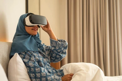 Simulating a fantasy world, entertainment by watching through virtual reality glasses, a veiled Saudi Arabian Gulf woman wearing an abaya looking through 3D glasses, trying to touch something with expressions of integration