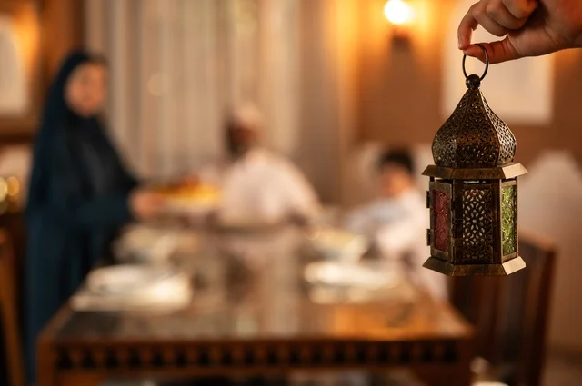 زينة المناسبات الإسلامية، تبادل الأحاديث بين أفراد الأسرة، أجواء عائلية دينية رمضانية سعيدة، عائلة عربية خليجية سعودية مجتمعة حول مائدة الطعام، سفرة مليئة بأصناف من المأكولات الشرقية الشهية، أداء فريضة الصيام في شهر رمضان المبارك