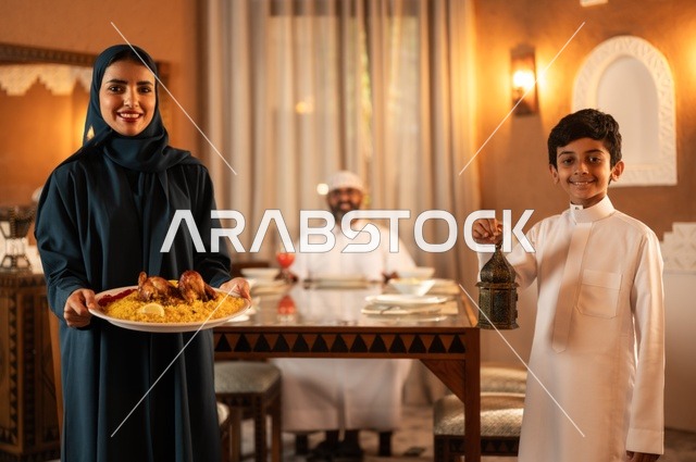 تبادل الأحاديث بين أفراد الأسرة، أجواء عائلية دينية رمضانية سعيدة، عائلة عربية خليجية سعودية مجتمعة حول مائدة الطعام، سفرة مليئة بأصناف من المأكولات الشرقية الشهية، أداء فريضة الصيام في شهر رمضان المبارك، زينة المناسبات الإسلامية