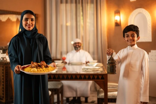 Exchanging conversations among family members, happy religious Ramadan family atmosphere, a Saudi Gulf Arab family gathered around the dining table, a spread filled with various delicious Eastern dishes, performing the fasting obligation in the blessed month of Ramadan, decorations for Islamic occasions.