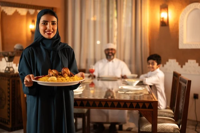 ايماءات السرور لاجتماع العائلة حول مائدة إفطار رمضان، أجواء عائلية روحانية دينية إسلامية، عائلة عربية خليجية سعودية مجتمعة حول مائدة الطعام، سفرة مليئة بأصناف من المأكولات الشرقية الشهية، أداء فريضة الصيام في شهر رمضان المبارك، موعد كسر الصيام عند الأذان