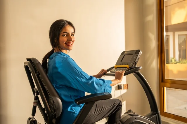 Physical activities to maintain fitness and agility, gestures of happiness and activity, following a healthy lifestyle using technological devices, sports to strengthen muscles and sculpt the body, a side image of a young Arab Gulf Saudi woman wearing sportswear exercising.