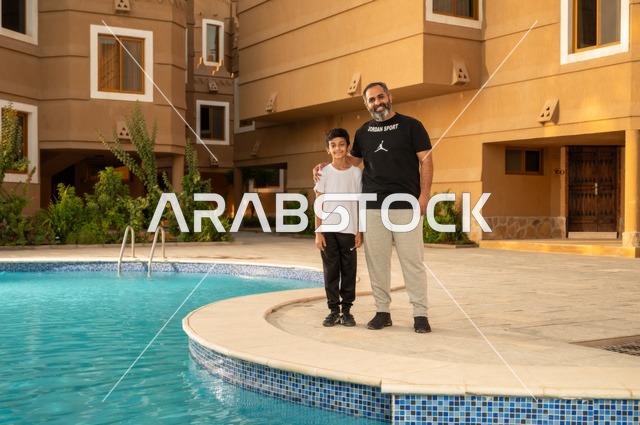 قضاء العطلة الصيفية في المنتجعات السياحية, مشاركة العائلة اللحظات الممتعة, القيام بالأنشطة الترفيهية المسلية, اب عربي خليجي سعودي يقف بجانب حوض السباحة مع ولده في إحدى الفنادق بالسعودي، ممارسة رياضة السباحة الممتعة