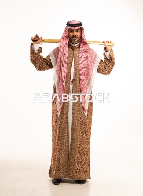 حمل السيف بتباهي وفخر احتفالا بيوم بدينا ١٧٢٧م، النظر إلى الكاميرا بإيماءات الاعتزاز، ارتداء الأزياء الشعبية في المناسبات الوطنية, بورتريه لرجل عربي خليجي سعودي يرتدي الشماغ والدقلة ، ذكرى تأسيس الدولة السعودية الأولى في 22 فبراير، صورة لكامل الجسم، خلفية بيضاء