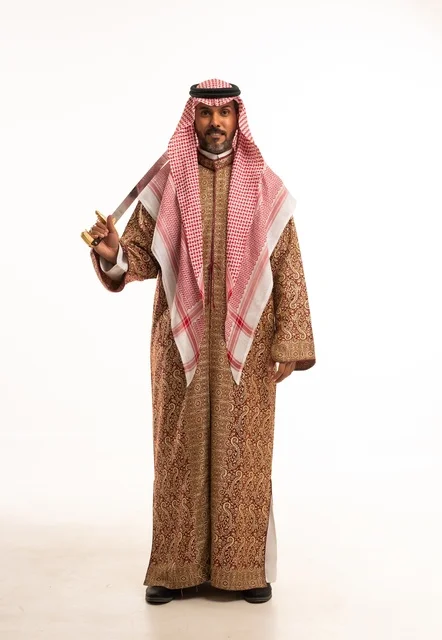 Carrying the sword with pride and honor in celebration of the Day of Bidaya 1727 AD, looking at the camera with gestures of pride, wearing traditional attire for national occasions, a portrait of an Arab Gulf Saudi man wearing the ghutrah and thobe, commemorating the founding of the first Saudi state on February 22, full-body image, white background.