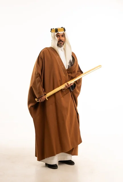 Carrying the sword with pride and honor in celebration of the Day of Bidaya 1727 AD, wearing traditional attire on national occasions, a portrait of an Arab Gulf Saudi man wearing the bisht and the founding agal, commemorating the establishment of the first Saudi state on February 22, full-body image, white background.