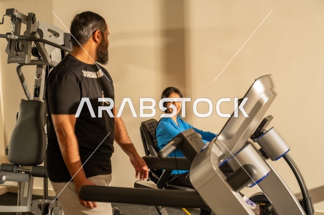Exchanging entertaining conversations while exercising, maintaining fitness and physical agility, a Saudi Arabian man and woman wearing sports attire and engaging in morning exercise, a healthy lifestyle, spending enjoyable times with family outdoors.
