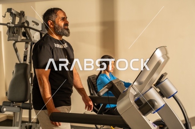 القيام بالتمارين للحفاظ على اللياقة، الحفاظ على اللياقة والرشاقة البدنية، رجل وامرأة عربيان خليجيان سعوديان يرتديان الزي الرياضي ويقومان بممارسة الرياضة الصباحية، نمط الحياة الصحية، قضاء أوقات ممتعة مع العائلة في الخارج