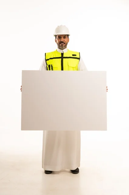 عرض موك اب أبيض فارغ كبير، بورتريه لمهندس عربي خليجي سعودي يرتدي الثوب التقليدي والسترة وخوذة الحماية يعمل في القطاع الهندسي في المملكة العربية السعودية، ادارة المشاريع الهندسية والانشاءات، مفهوم دراسة المخطط ومشروع البناء، الجسم بالطول الكامل، خلفية بيضاء