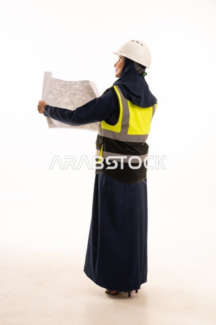 متابعة وقراءة المخططات الهندسية، دور الهندسة الإنشائية في تطور المجتمع السعودي، دور الهندسة الإنشائية في تطور المجتمع السعودي, بورتريه لمهندسة عربية خليجية سعودية مسلمة محجبة ترتدي الخوذة البيضاء وسترة الحماية، الجسم بالطول الكامل، خلفية بيضاء